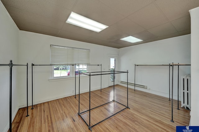2406 J St, Lincoln, NE 68510 - interior space featuring wood finished floors, a drop ceiling, a baseboard radiator, radiator heating unit, and baseboards