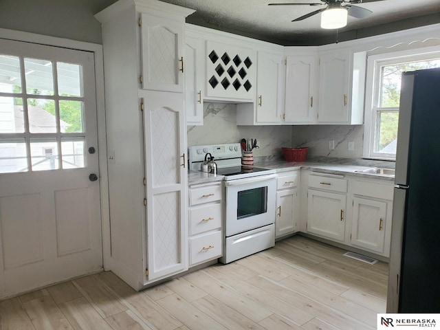 6512 Maple St, Omaha, NE 68104 - kitchen featuring electric range, freestanding refrigerator, a ceiling fan, light countertops, and white cabinets