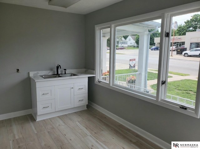 6512 Maple St, Omaha, NE 68104 - laundry room with a sink, baseboards, and light wood-type flooring