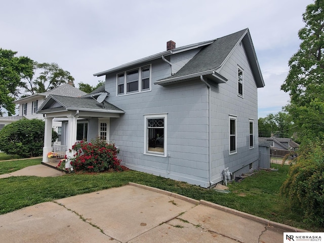 6512 Maple St, Omaha, NE 68104 - back of property featuring a chimney, roof with shingles, a lawn, a patio, and covered porch