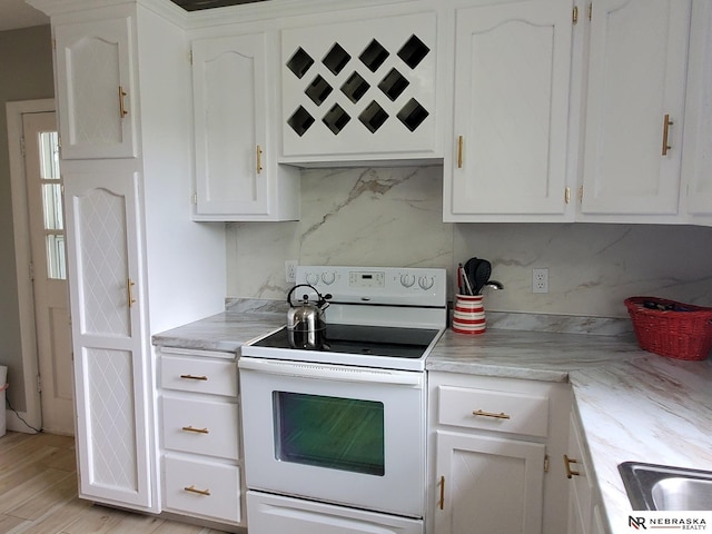 6512 Maple St, Omaha, NE 68104 - kitchen with electric range, white cabinetry, and light countertops