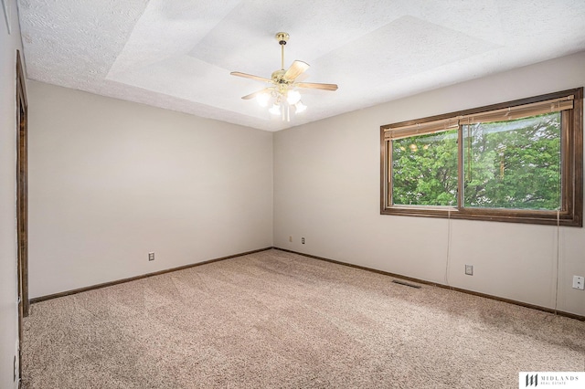 unfurnished room with visible vents, carpet floors, and a textured ceiling