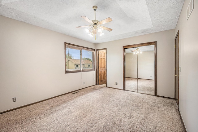 unfurnished bedroom with a textured ceiling, visible vents, and light colored carpet