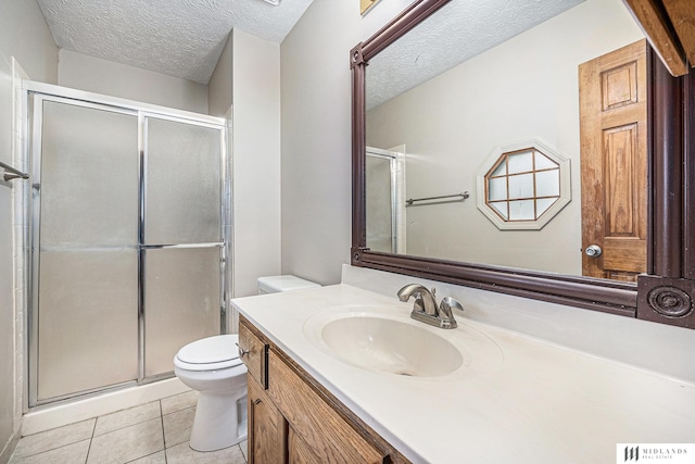 full bathroom with a textured ceiling, a stall shower, toilet, vanity, and tile patterned flooring
