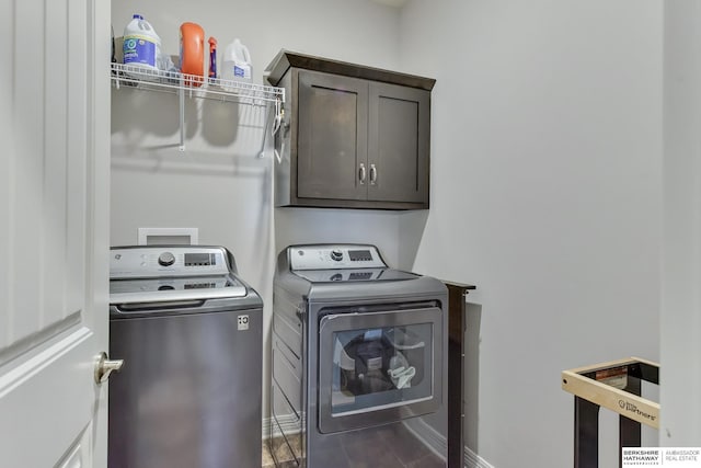 clothes washing area featuring baseboards, cabinet space, and independent washer and dryer