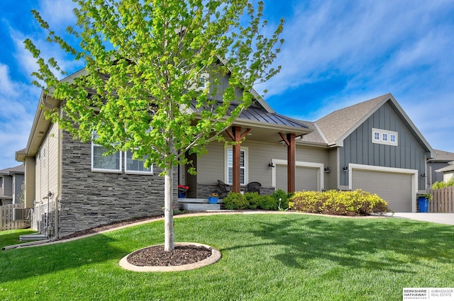 view of front of home featuring a front lawn, stone siding, a garage, board and batten siding, and driveway