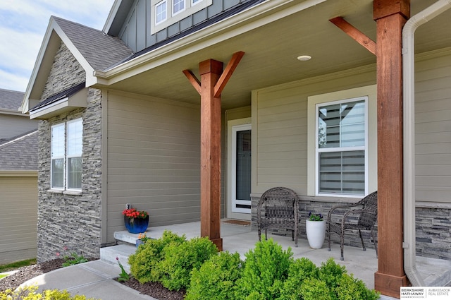 view of exterior entry with a porch, board and batten siding, and stone siding