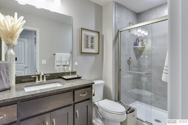 bathroom with vanity, a shower stall, and toilet