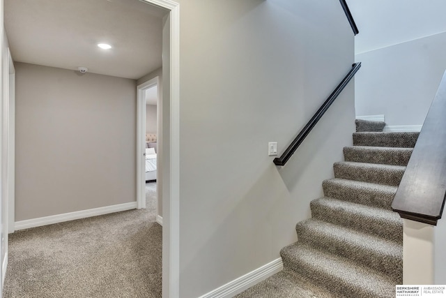 staircase with baseboards and carpet floors