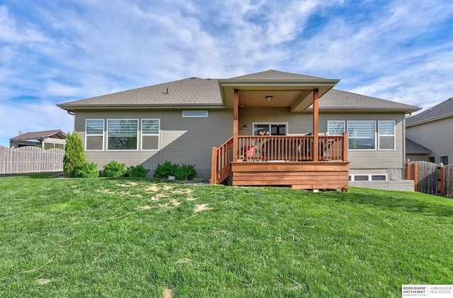 rear view of property featuring fence, a yard, and a deck