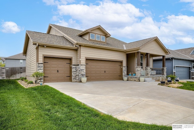 craftsman inspired home with a front yard, a shingled roof, covered porch, concrete driveway, and an attached garage