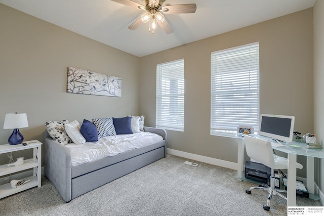 carpeted office featuring visible vents, a ceiling fan, and baseboards