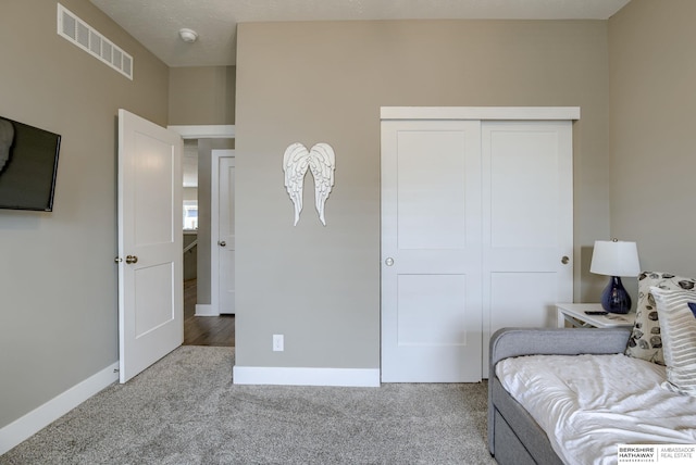 bedroom with carpet flooring, a closet, visible vents, and baseboards