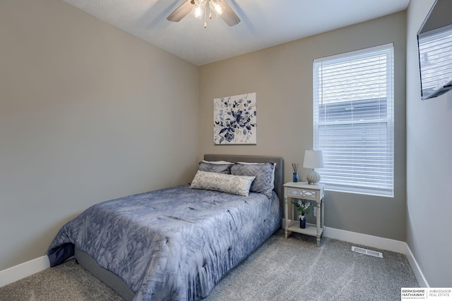 carpeted bedroom with visible vents, baseboards, and multiple windows