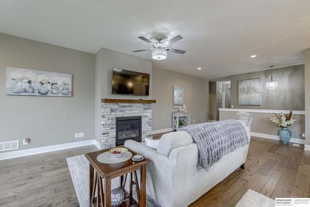 living room with visible vents, a ceiling fan, baseboards, and wood-type flooring