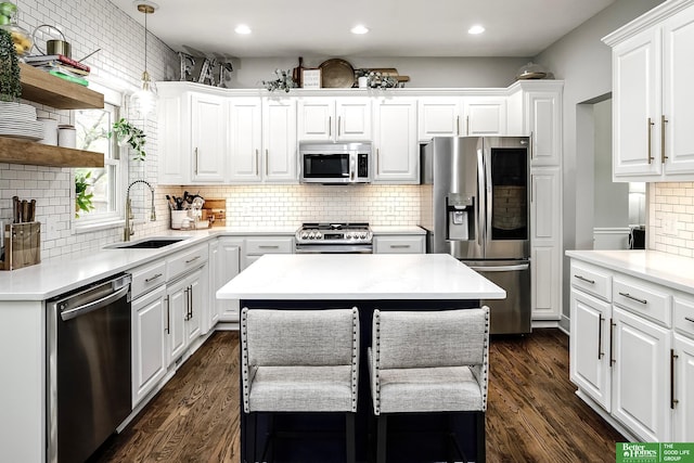 kitchen featuring a sink, decorative backsplash, light countertops, white cabinets, and appliances with stainless steel finishes