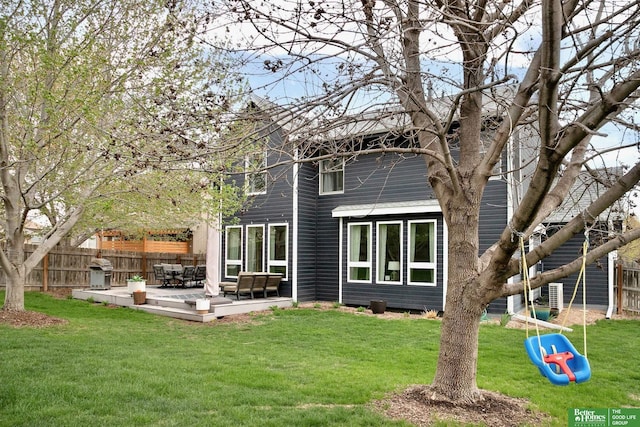 rear view of house featuring fence, a yard, and a patio