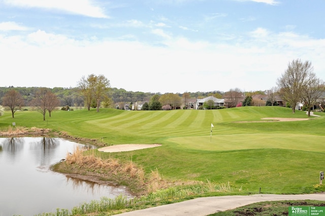 view of community with a lawn, a water view, and view of golf course