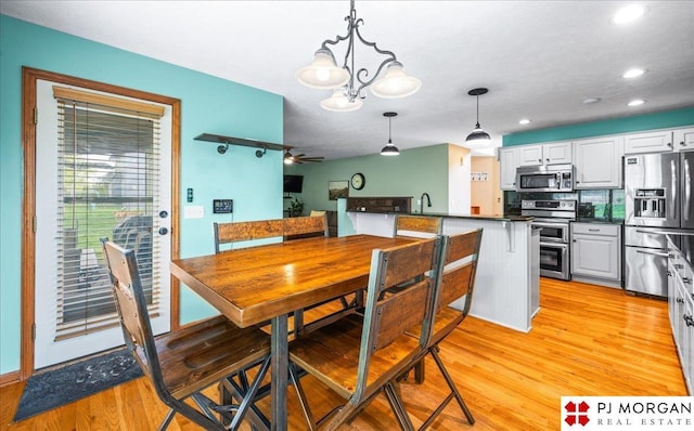 dining area featuring recessed lighting, ceiling fan with notable chandelier, and light wood finished floors