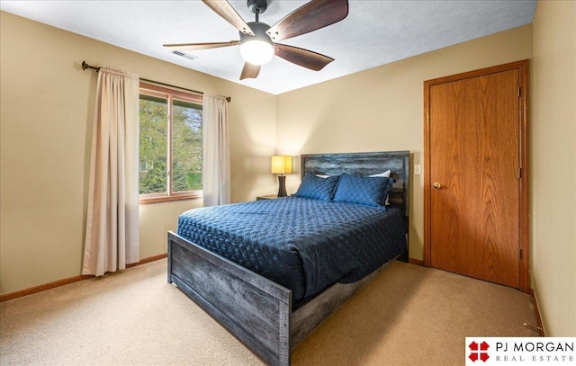 bedroom with baseboards, visible vents, a ceiling fan, and light carpet