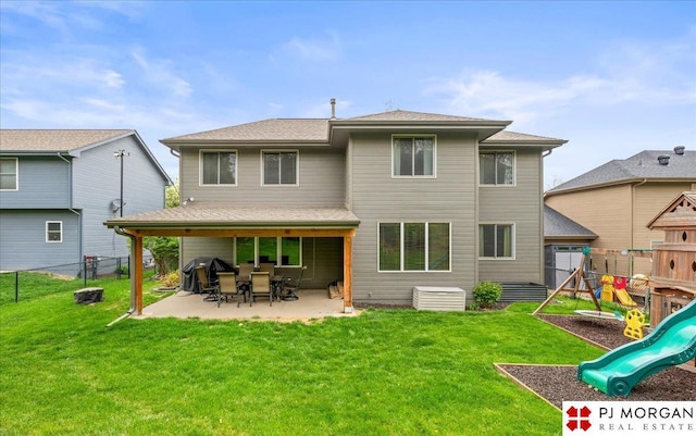 back of property with a lawn, a playground, a fenced backyard, and a patio area