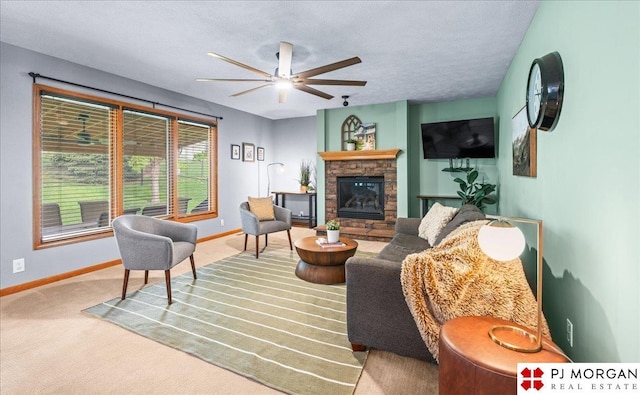 living room featuring a ceiling fan, a stone fireplace, carpet, and baseboards
