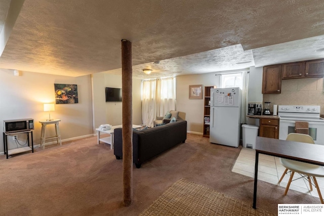 kitchen featuring a textured ceiling, white appliances, carpet flooring, and baseboards