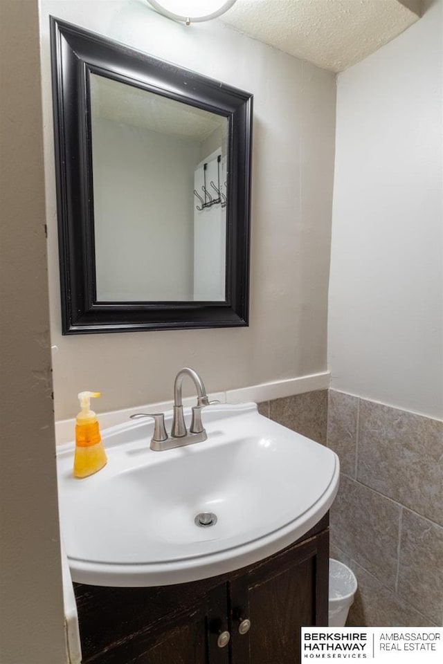 bathroom with toilet, a textured ceiling, and vanity