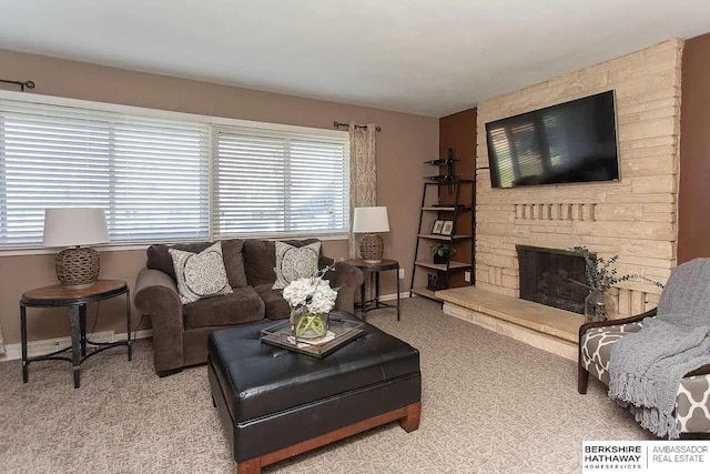 living room featuring carpet floors, a stone fireplace, and baseboards