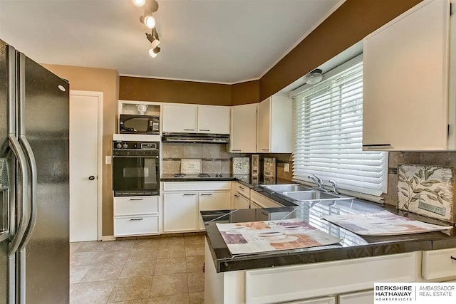 kitchen featuring black appliances, a sink, dark countertops, backsplash, and under cabinet range hood