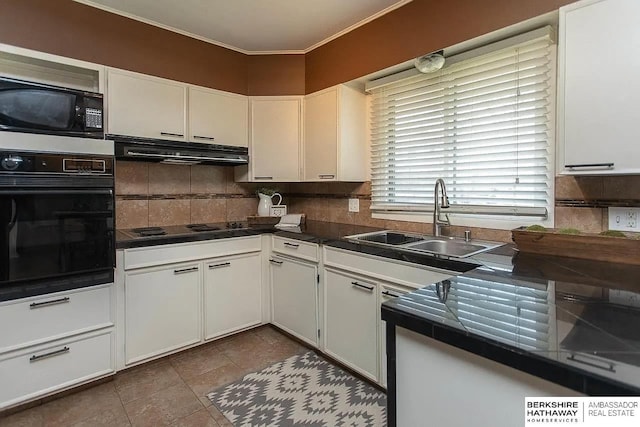 kitchen with black appliances, a sink, under cabinet range hood, dark countertops, and decorative backsplash