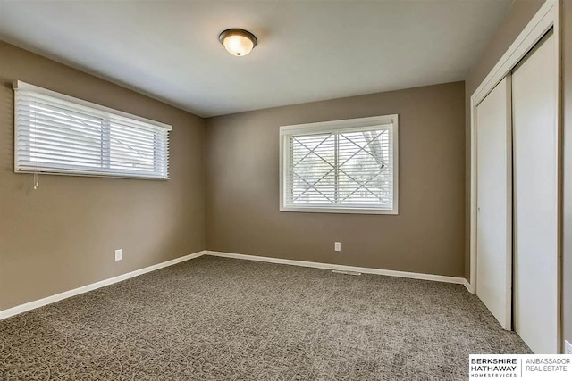 unfurnished bedroom featuring a closet, carpet floors, and baseboards