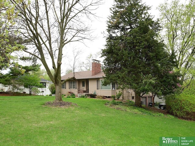 600 Ridgewood Ave, Omaha, NE 68114 - exterior space featuring a chimney, a front yard, and a garage