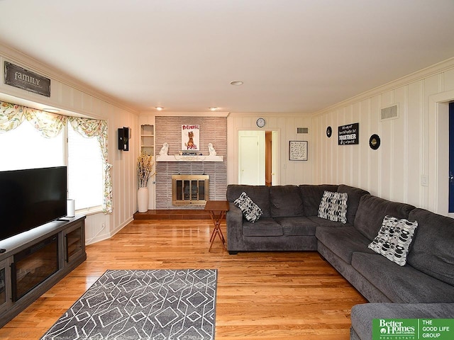 600 Ridgewood Ave, Omaha, NE 68114 - living room with a fireplace, light wood finished floors, visible vents, and ornamental molding