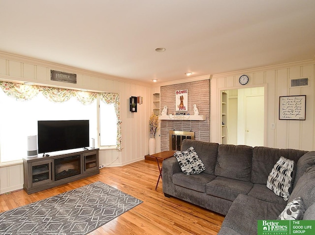 600 Ridgewood Ave, Omaha, NE 68114 - living room with light wood finished floors, a fireplace, visible vents, a decorative wall, and ornamental molding