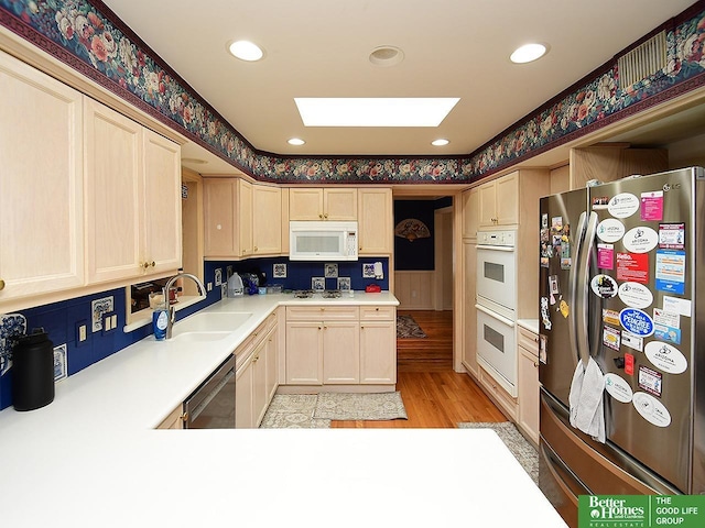600 Ridgewood Ave, Omaha, NE 68114 - kitchen featuring light brown cabinetry, appliances with stainless steel finishes, light countertops, a sink, and light wood-type flooring
