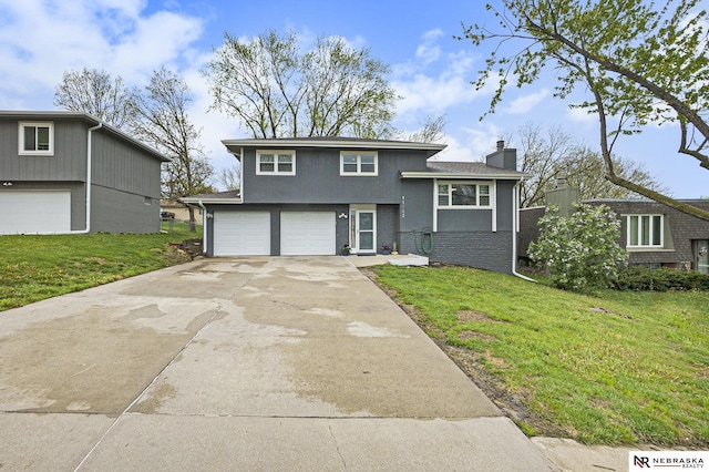 split level home with a front lawn, concrete driveway, a chimney, and an attached garage