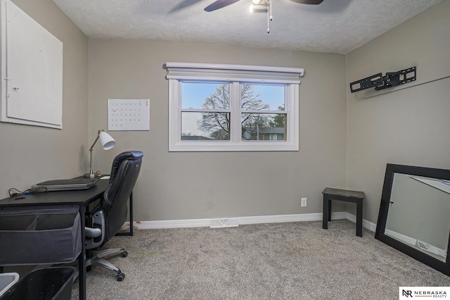 carpeted office space with a textured ceiling, visible vents, a ceiling fan, and baseboards