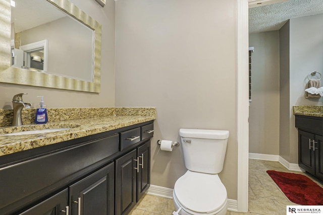 bathroom featuring tile patterned floors, toilet, vanity, and a textured ceiling