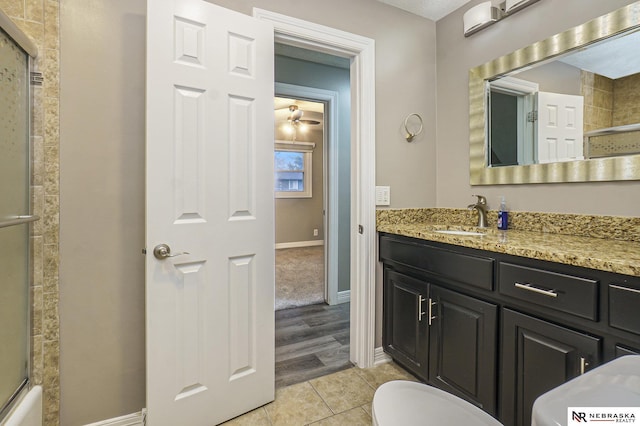 full bath featuring tile patterned floors, toilet, vanity, and baseboards