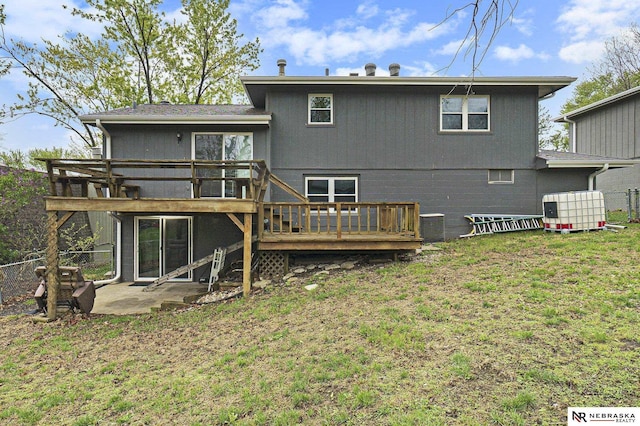 back of house with a deck, fence, a patio, and a lawn