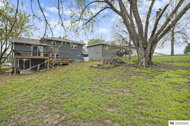 view of yard with fence, a wooden deck, and a sunroom