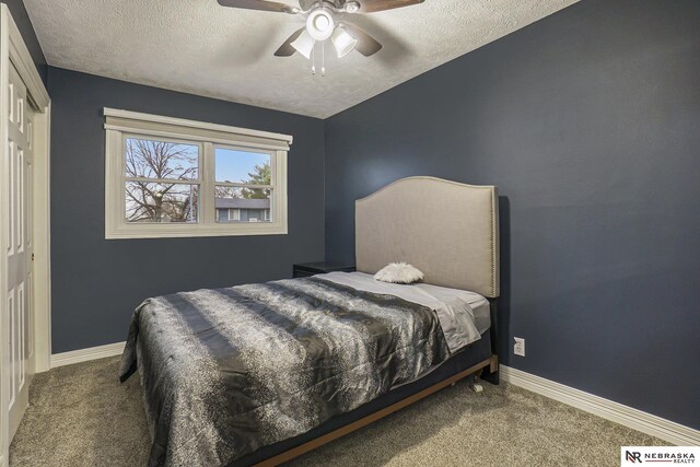 bedroom featuring a textured ceiling, carpet flooring, and baseboards
