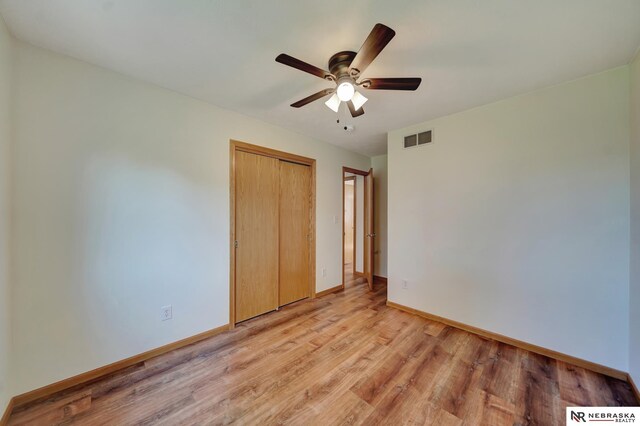 1521 Morton St, Lincoln, NE 68521 - unfurnished bedroom featuring baseboards, light wood-style floors, a closet, and a ceiling fan