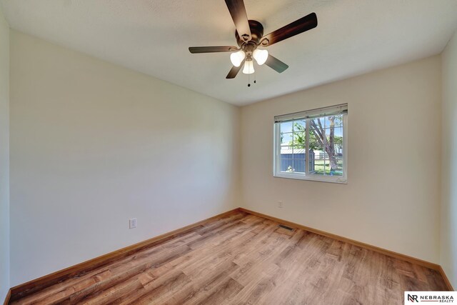 1521 Morton St, Lincoln, NE 68521 - spare room featuring light wood-style floors, baseboards, and a ceiling fan