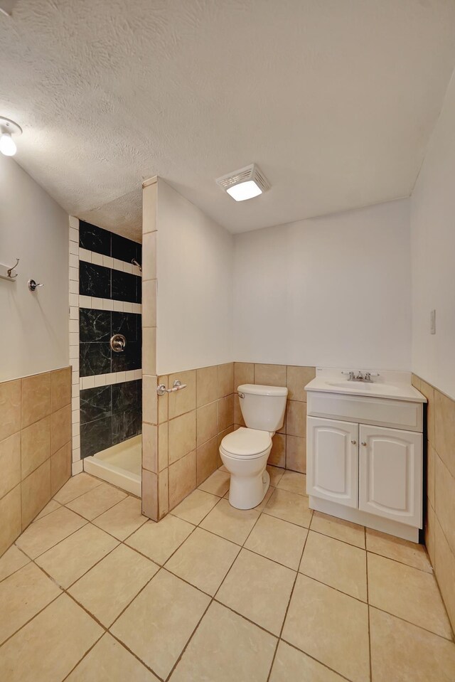 1521 Morton St, Lincoln, NE 68521 - full bath featuring tile walls, tiled shower, toilet, a wainscoted wall, and tile patterned flooring