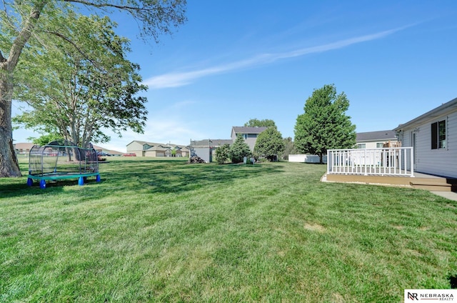 1521 Morton St, Lincoln, NE 68521 - view of green lawn with a trampoline and a deck