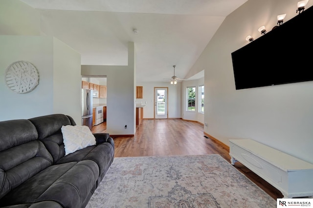 1521 Morton St, Lincoln, NE 68521 - living room featuring light wood-style floors, a ceiling fan, baseboards, and high vaulted ceiling