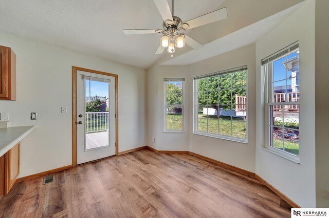 1521 Morton St, Lincoln, NE 68521 - unfurnished dining area featuring plenty of natural light, light wood-style flooring, baseboards, a ceiling fan, and lofted ceiling
