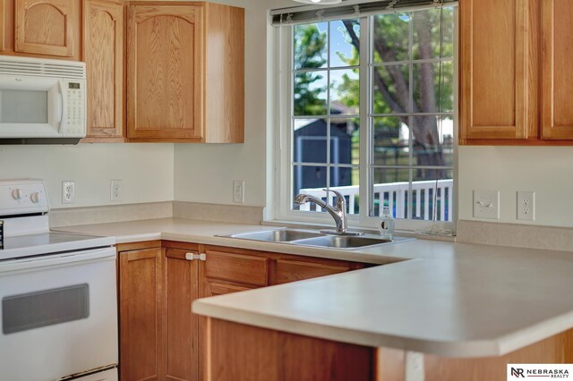 1521 Morton St, Lincoln, NE 68521 - kitchen with white appliances, a sink, healthy amount of natural light, and light countertops